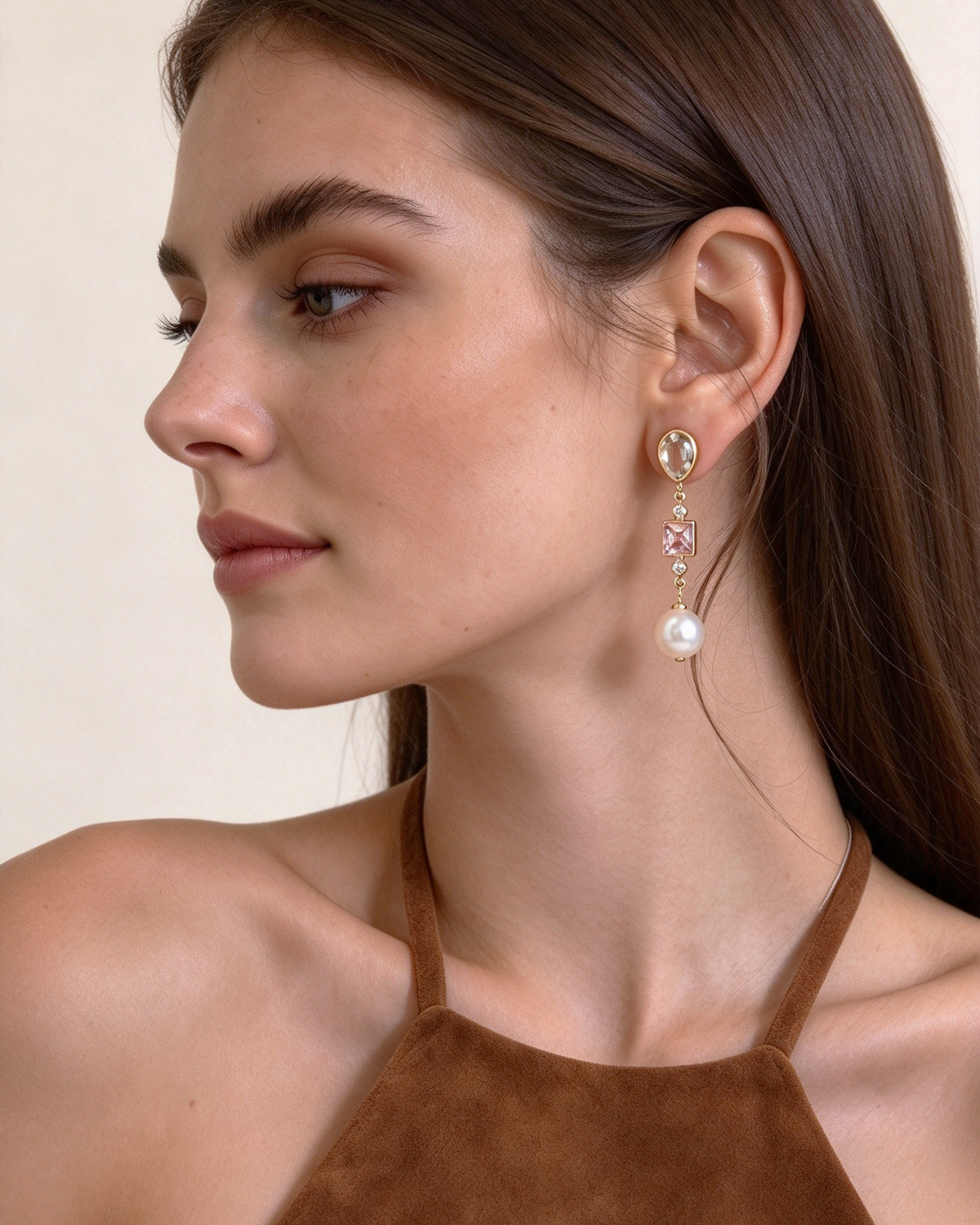 Close-up of synthetic pearl drop earrings with geometric design