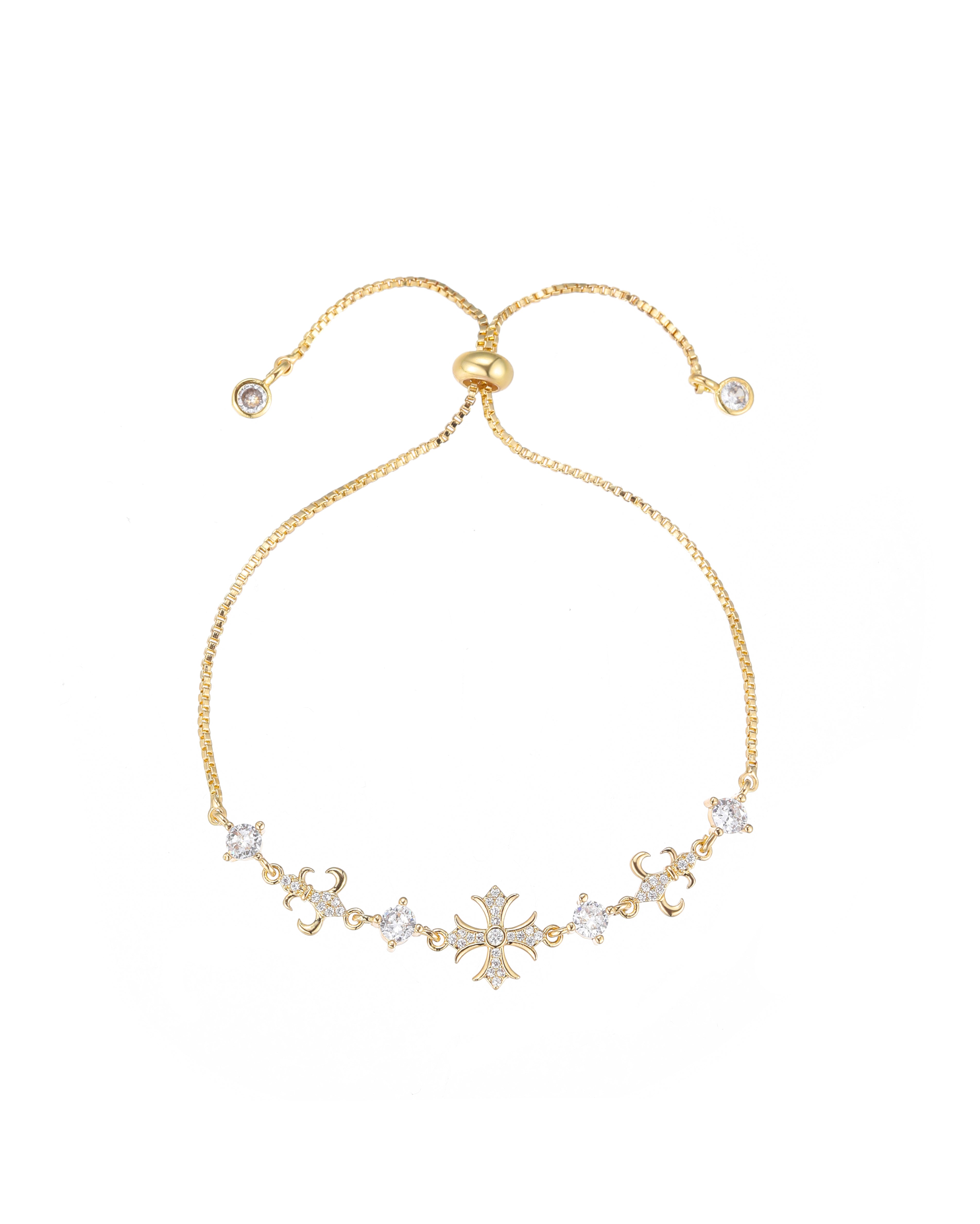 Gold-plated brass slider bracelet featuring a pavé cubic zirconia cross centerpiece, fleur-de-lis accents, and adjustable bolo mechanism with end charms.