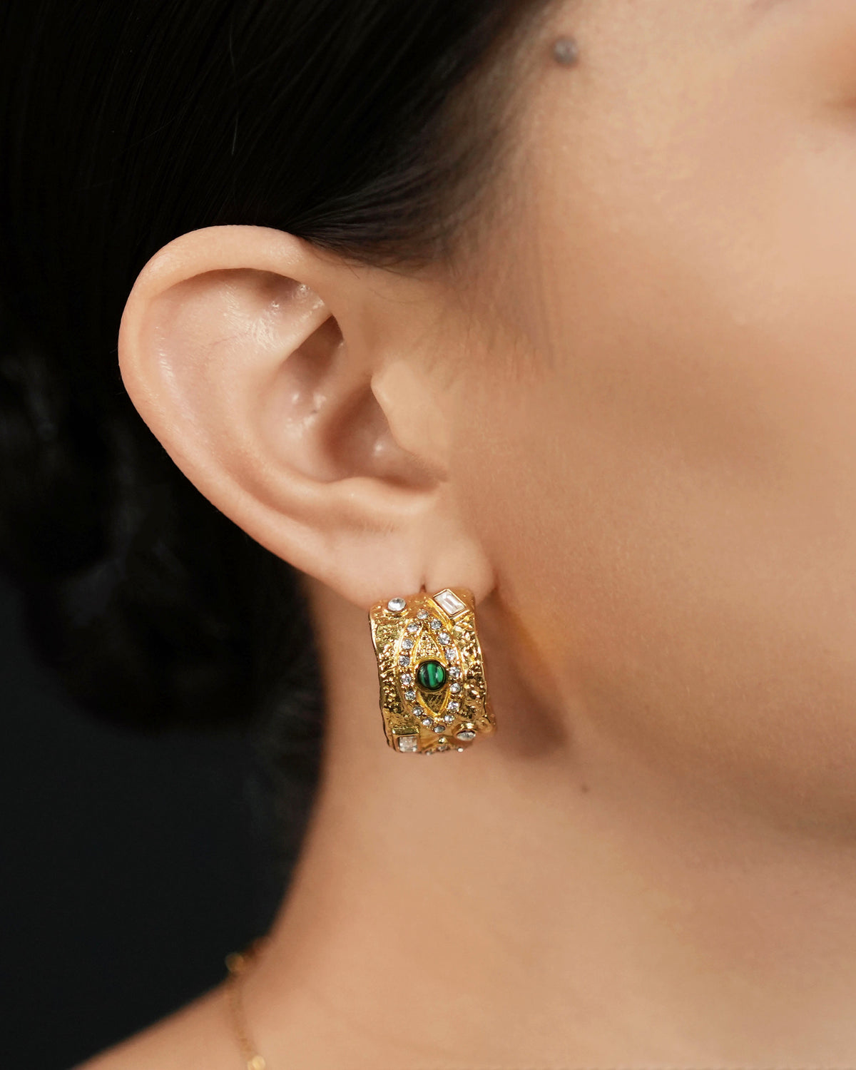 model wearing evil eye hoop earrings gold