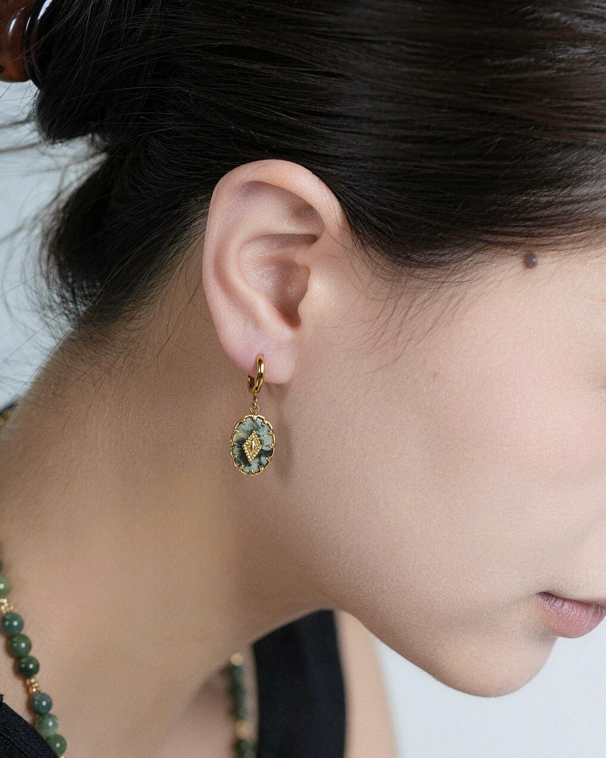 Close-up of turquoise stone drop earrings showing polished teal gemstones